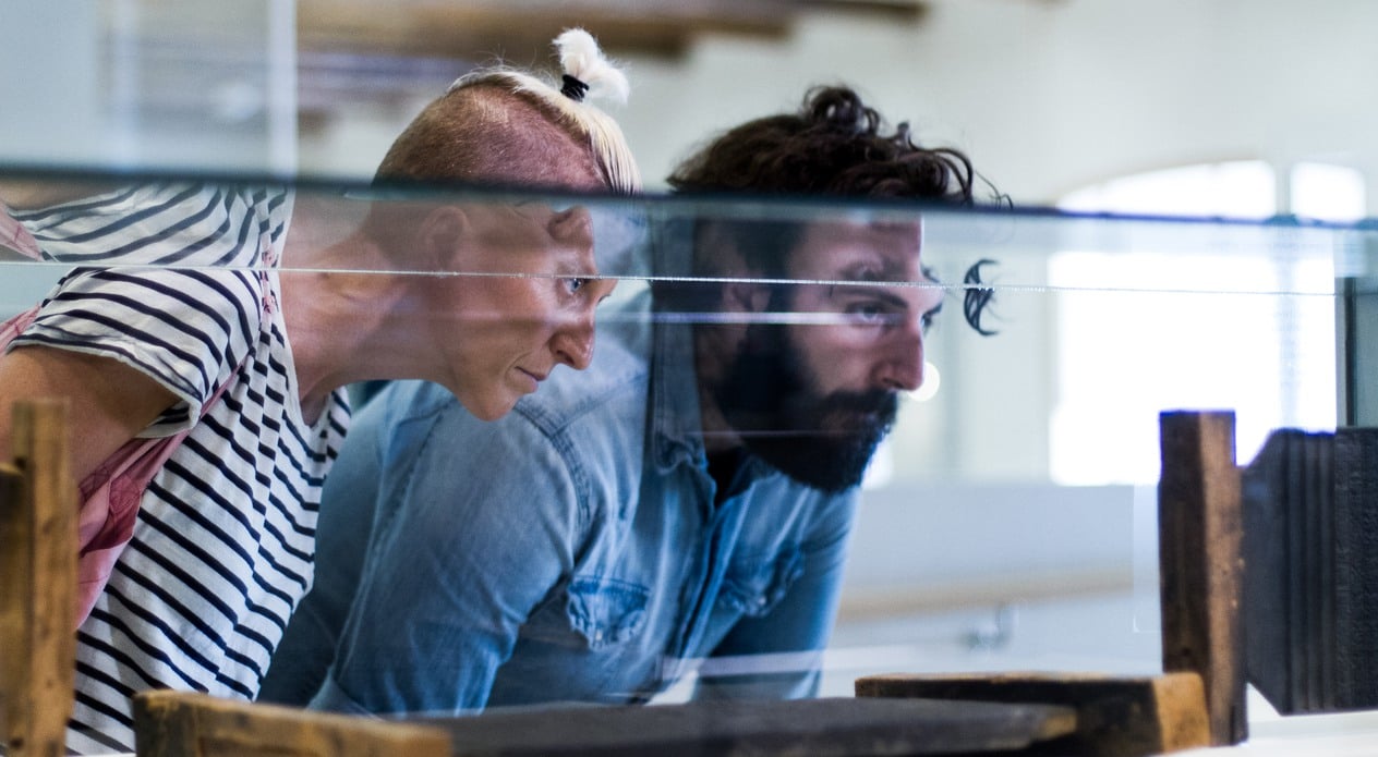 Two people looking at a exhibition. Photo.