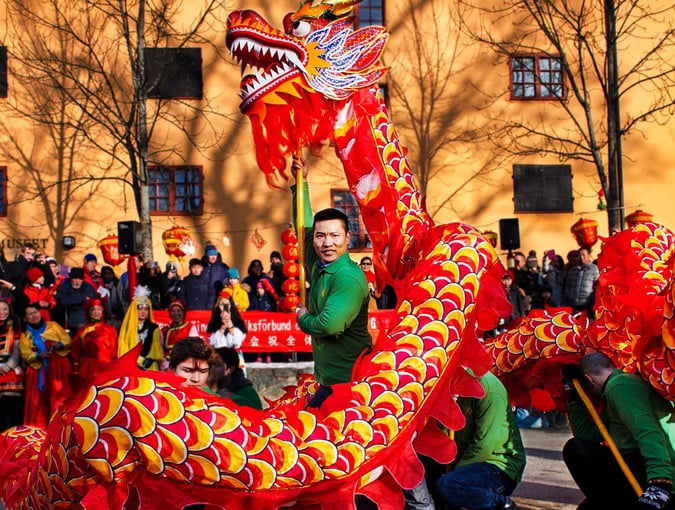 Man med drakfigur. Foto.