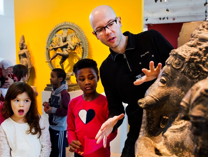 Pedagog visar barn ett föremål på museet. Fotografi.
